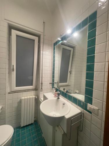 a white bathroom with a sink and a mirror at Minerva Home in Salerno