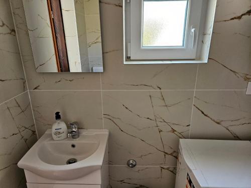 a bathroom with a sink and a mirror at Apartment Klara in Senj