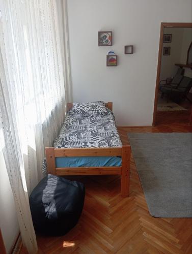 a bedroom with a bed and a ottoman at MAM apartmani in Bosanski Brod