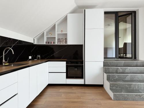 a kitchen with white cabinets and black counter tops at Peaceful Place Near Lake in Sankt Pölten