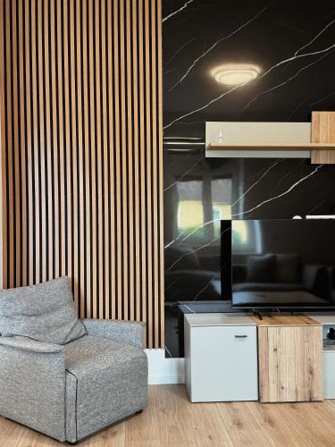 a living room with a chair and a television at Peaceful Place Near Lake in Sankt Pölten