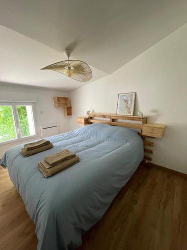 a bedroom with a large bed with two towels on it at Le Gîte de Julia in Saint-Laurent-de-Médoc