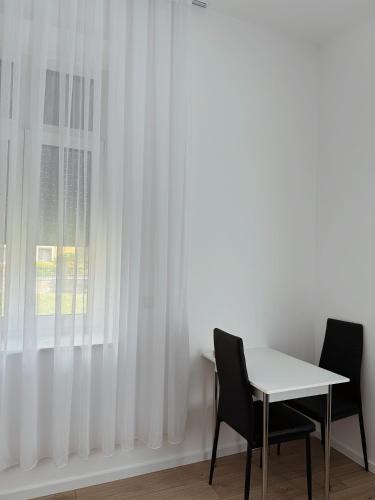 a table and two chairs in front of a window at Peaceful Place Near Lake in Sankt Pölten