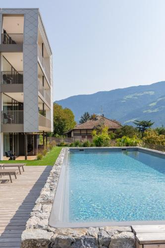 a swimming pool in front of a building at Marchegg Apartments in Naturno