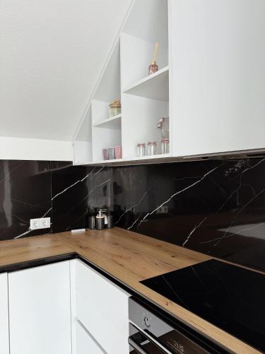 a kitchen with white cabinets and black counter tops at Peaceful Place Near Lake in Sankt Pölten