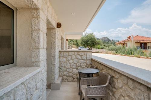 a stone walled patio with a table and chairs at PALELIA living in the olive garden in Nafplio