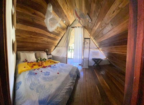 a bed in a room with a wooden ceiling at Dreamvilles Ecovillage Las Galeras in Las Galeras