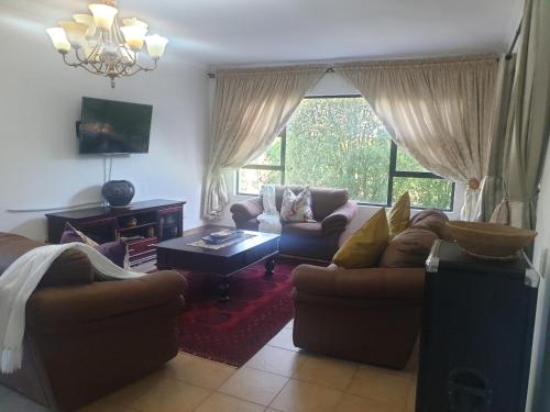 a living room with two couches and a table at Mountain View Guest House in Underberg in Underberg