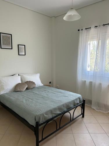 a bed in a white bedroom with a window at The middle apartment in Virós