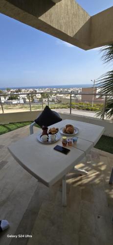 a white table with a plate of food on it at Bizerte Résidence soltana RDC vue mer in Bizerte