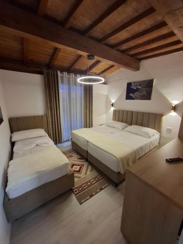 a bedroom with two beds and a large window at Guesthouse Alberti Llogara in Shalë