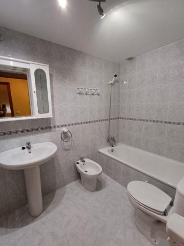 a bathroom with a sink and a toilet and a bath tub at Apartamento la Costa in Colunga