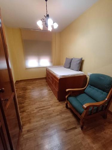 a bedroom with a bed and a chair and a window at Apartamento la Costa in Colunga