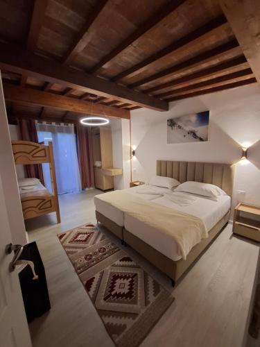a bedroom with a large bed in a room with wooden ceilings at Guesthouse Alberti Llogara in Shalë