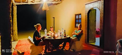 a group of women sitting at a table in a room at Sahara Sunset Camp M'hamid in Mhamid