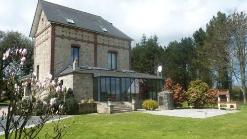 uma grande casa de tijolos com uma grande janela em La maison des musiciens em Digosville