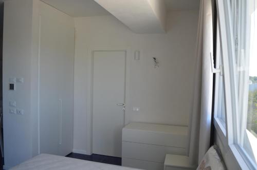 Un baño blanco con inodoro y ventana. en Lu rusciu te lu mare, en Maruggio