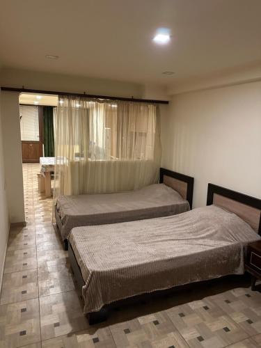 a bedroom with two beds and a window at Friends & Family II in Yerevan