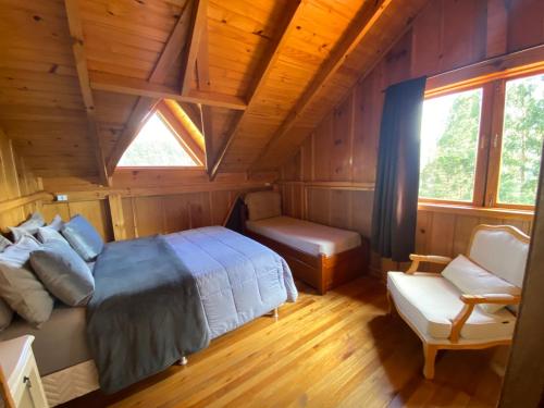a bedroom with a bed and a bench in a cabin at Chalés Sol da Serra in Rio Rufino