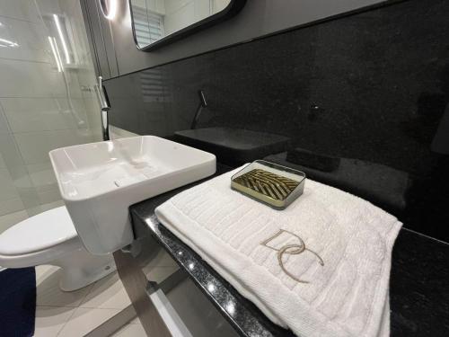 a bathroom with a sink and a white towel at Loft Dona Clara 201 Centro de Pomerode in Pomerode