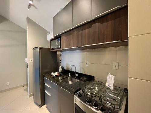 a kitchen with a sink and a stainless steel refrigerator at Loft Dona Clara 201 Centro de Pomerode in Pomerode
