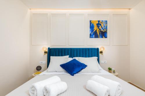 a bedroom with a blue and white bed with white pillows at Wine house apartments & rooms Marčeta in Fažana