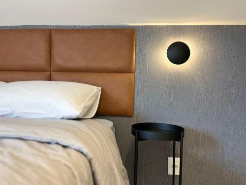 a bedroom with a bed and a black stool at Loft Dona Clara 201 Centro de Pomerode in Pomerode