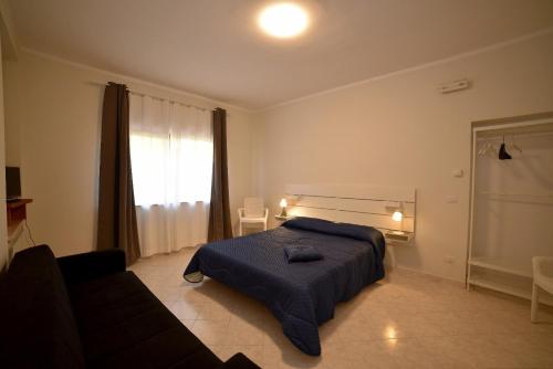 a bedroom with a bed and a couch and a window at Casa del Lago in Bolsena