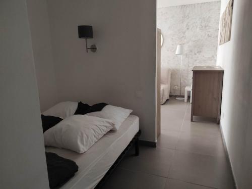 - un lit avec des oreillers blancs dans l'établissement appartement T1 Hyères, calme, piscine, clim, WIFI, parking, centre ville, à Hyères