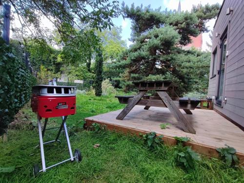 a grill and a picnic table in a yard at City TinyHouse under WaterTower in Wrocław