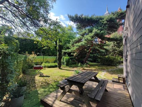 a wooden picnic table in a garden with a grill at City TinyHouse under WaterTower in Wrocław