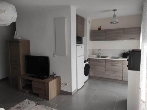 une cuisine avec une télévision sur une table en bois avec une cuisine dans l'établissement appartement T1 Hyères, calme, piscine, clim, WIFI, parking, centre ville, à Hyères