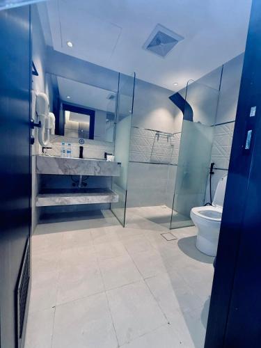 a bathroom with a toilet and a sink and a shower at Hyatt Buyutat Serviced Apartments in Riyadh