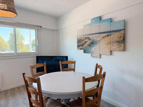 une salle à manger avec une table et des chaises blanches dans l'établissement Appartement tout confort avec parking, Aquarium, à La Rochelle