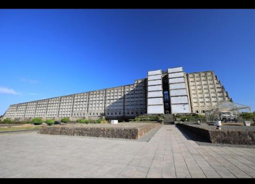 ein großes Gebäude mit vielen Fenstern in der Unterkunft Comodo y acogedor apartamento en Los Mameyes in Los Tres Ojos de Agua