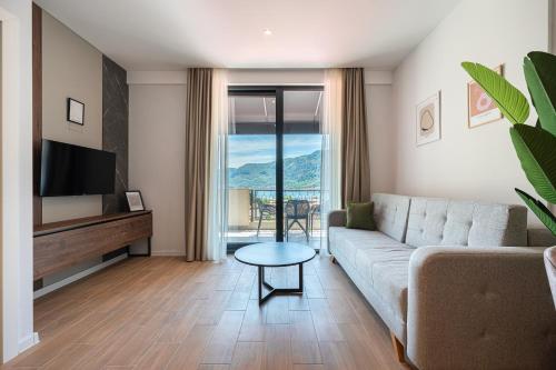 a living room with a couch and a tv at Bonita Residence in Dobrota