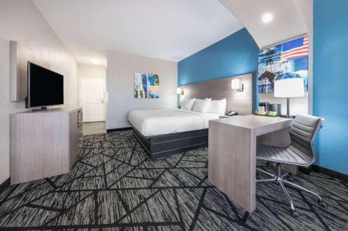 a hotel room with a bed and a desk and a television at La Quinta by Wyndham Alvarado in Alvarado