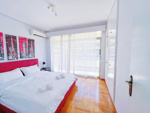 a bedroom with a large bed with a red headboard at Spacious 2BR by Floisvos Beach Saltwater Balcony in Athens