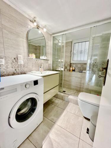 a bathroom with a washing machine and a toilet at Spacious 2BR by Floisvos Beach Saltwater Balcony in Athens