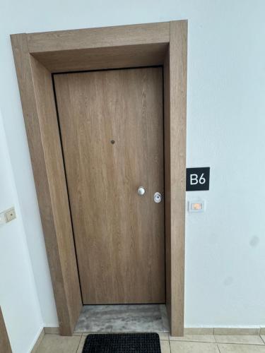 a wooden door with a sign that reads at Creta Apt Mela Β6 in Thérissos