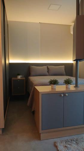 a bedroom with a bed with two potted plants on it at Studio Hub Brasil in Criciúma