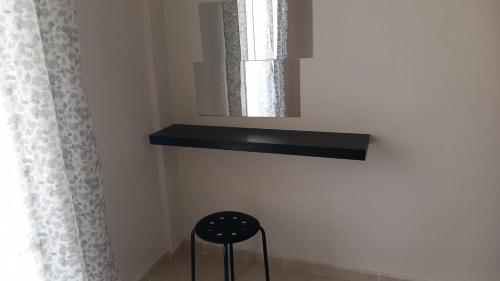 a stool in a room with a mirror and a window at stamatiou in Methana