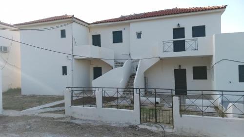 a white building with a staircase in front of it at stamatiou in Methana
