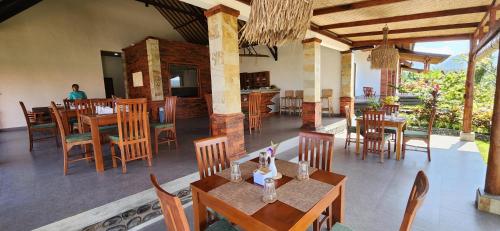a restaurant with wooden tables and chairs in a room at Terrace Retreat & Spa Medewi in Pulukan
