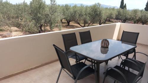 a blue table and chairs on a balcony with trees at stamatiou in Methana