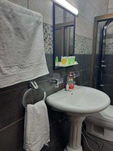 a bathroom with a sink and a mirror and a toilet at شاليه بانا جرش in Jerash