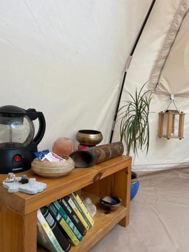 Una mesa con libros y un televisor y una tienda de campaña. en TroldeSlottet, en Rudkøbing