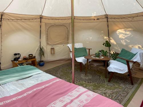 a bedroom with a bed and a table in a tent at TroldeSlottet in Rudkøbing