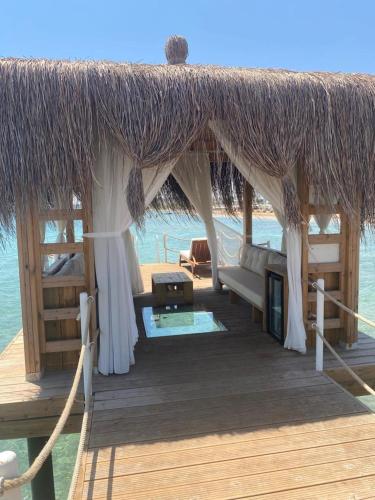 a pavilion with a couch and a table on the beach at Emerald seaside residence at Four Seasons in Boğaz