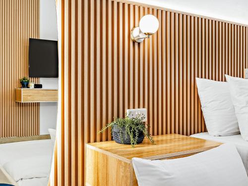 a room with a bed and a table with a plant on it at Yas Island Tranquil Studio in Abu Dhabi